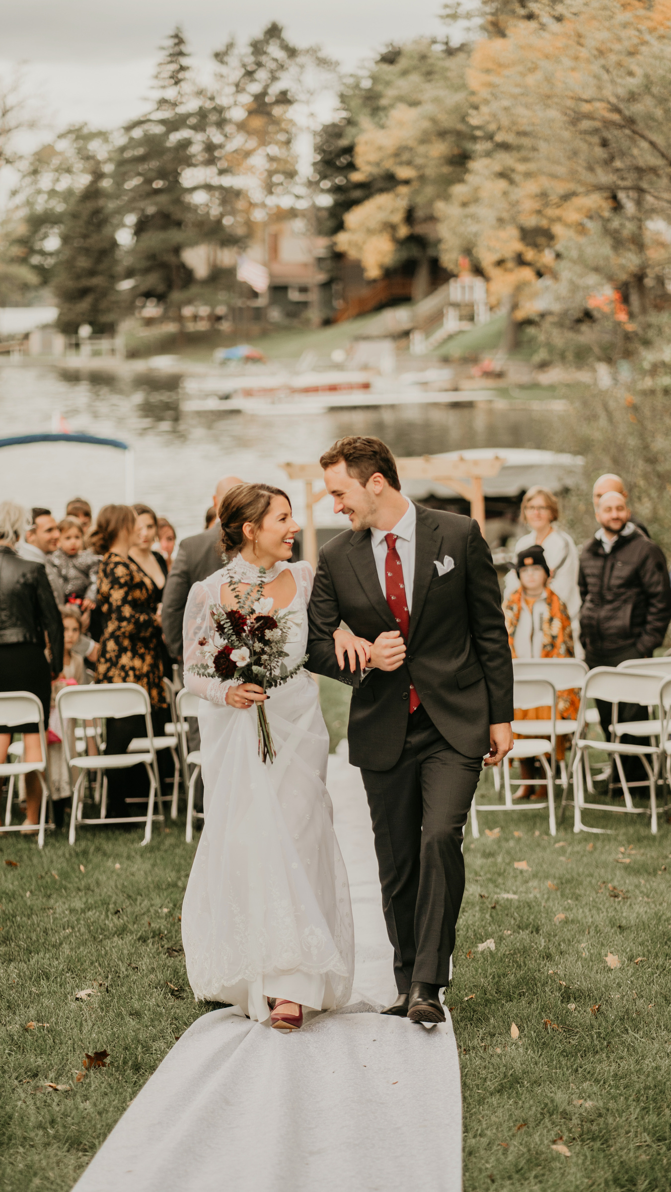 Wedding Photo of Couple Walking Down Aisle with Lake in Background